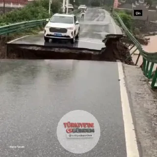 Çin'de sel nedeniyle çöken köprüdeki bir otomobil, şiddetli sulara kapılarak sürüklendi.
