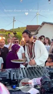 Genç bir kişi, köye sahne kuran Mahmut Orhan'ın konuklara yaprak sarması ikram ettiği anları paylaştı.