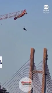 Çin'de bir yamaç paraşütü pilotu, paraşütünün yaklaşık 60 metre yüksekliğindeki bir inşaat vincine takılmasının ardından yara almadan kurtuldu.